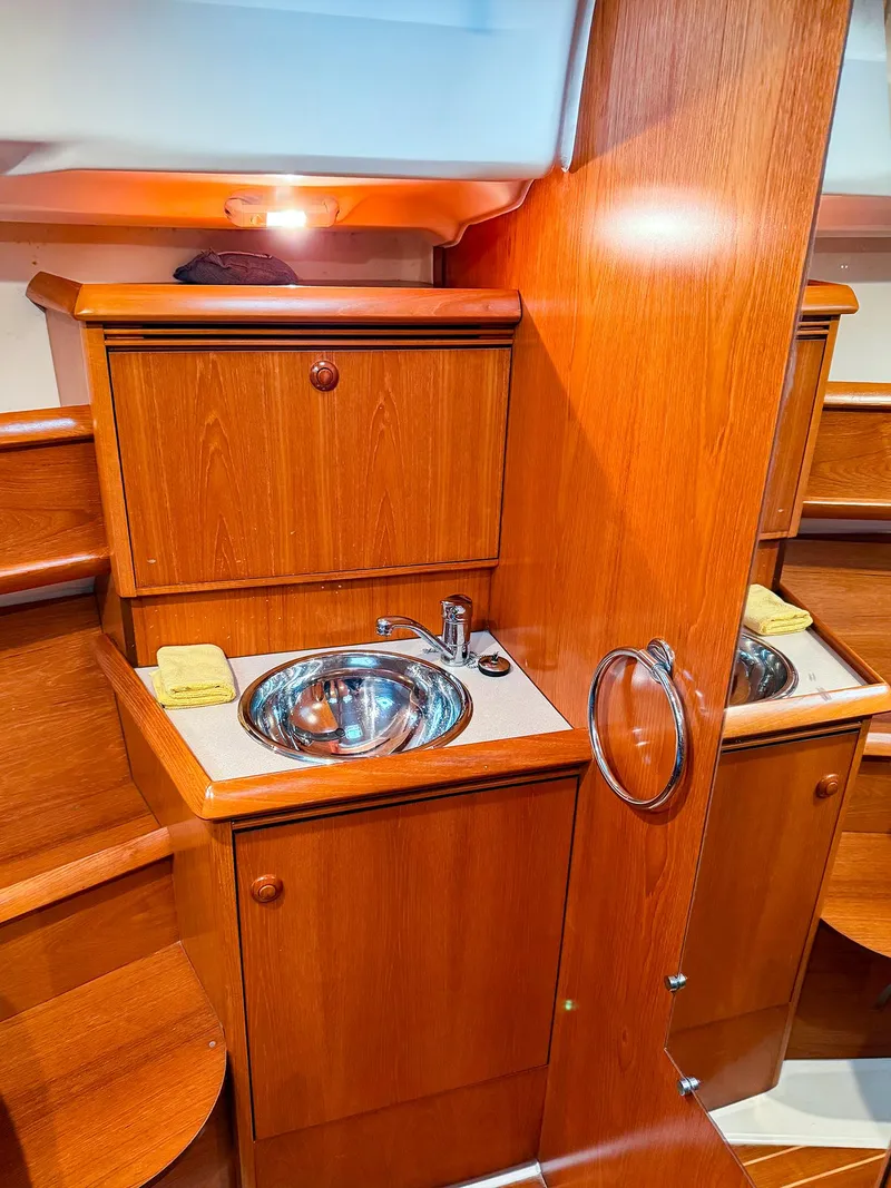 Slide: The Image of 2005 Jeanneau 40.3 yacht interior, featuring a wooden bathroom vanity with a stainless steel sink. - 33