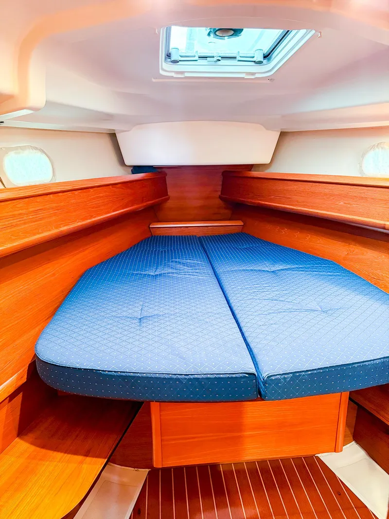 Slide: The Image of 2005 Jeanneau 40.3 yacht interior with cozy wooden cabin and blue mattress. - 34