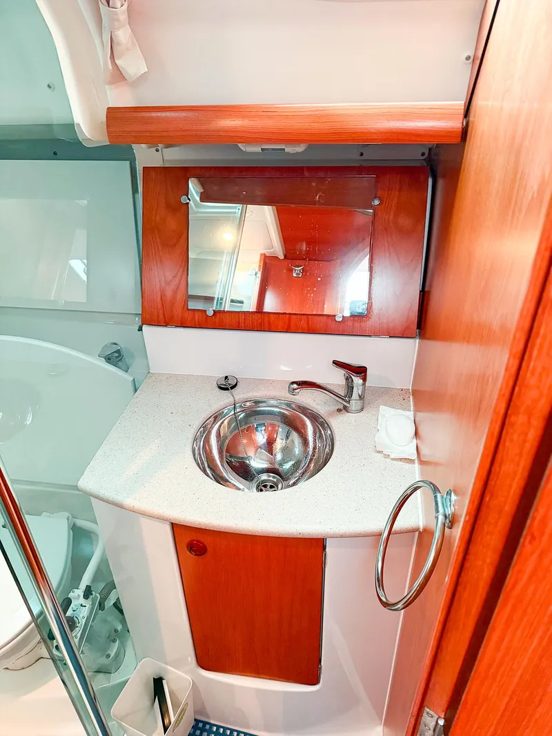Slide: The Image of 2005 Jeanneau 40.3 yacht bathroom with wooden cabinetry and stainless steel sink. - 40