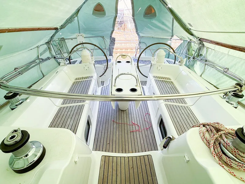 Slide: The Image of 2005 Jeanneau 40.3 sailboat cockpit with dual steering wheels and teak flooring. - 7