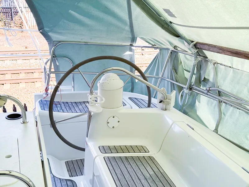 Slide: The Image of 2005 Jeanneau 40.3 sailboat cockpit with steering wheel and canopy. - 9