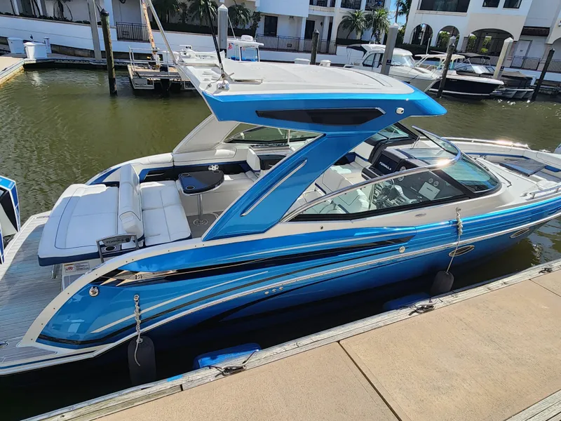 Slide: The Image of 2019 Formula 330 Crossover Bowrider OB in vibrant blue docked at marina. - 1