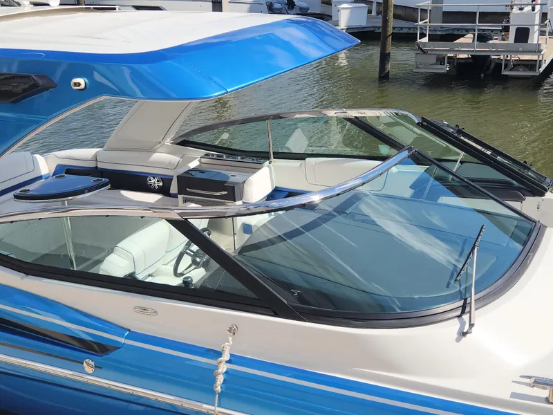 Slide: The Image of 2019 Formula 330 Crossover Bowrider OB with blue accents docked on water. - 2