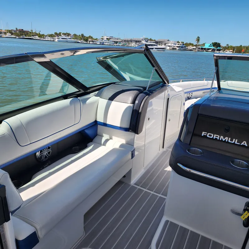 Slide: The Image of 2019 Formula 330 Crossover Bowrider OB interior with seating, on a sunny day by the water. - 22