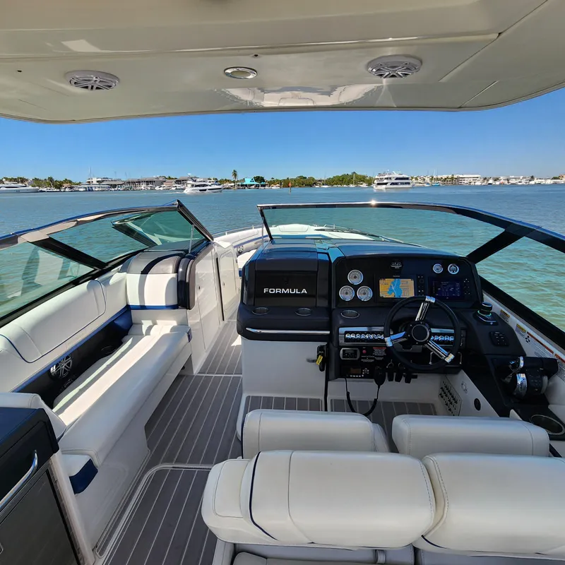 Slide: The Image of 2019 Formula 330 Crossover Bowrider OB interior with helm, seating, and water view. - 23