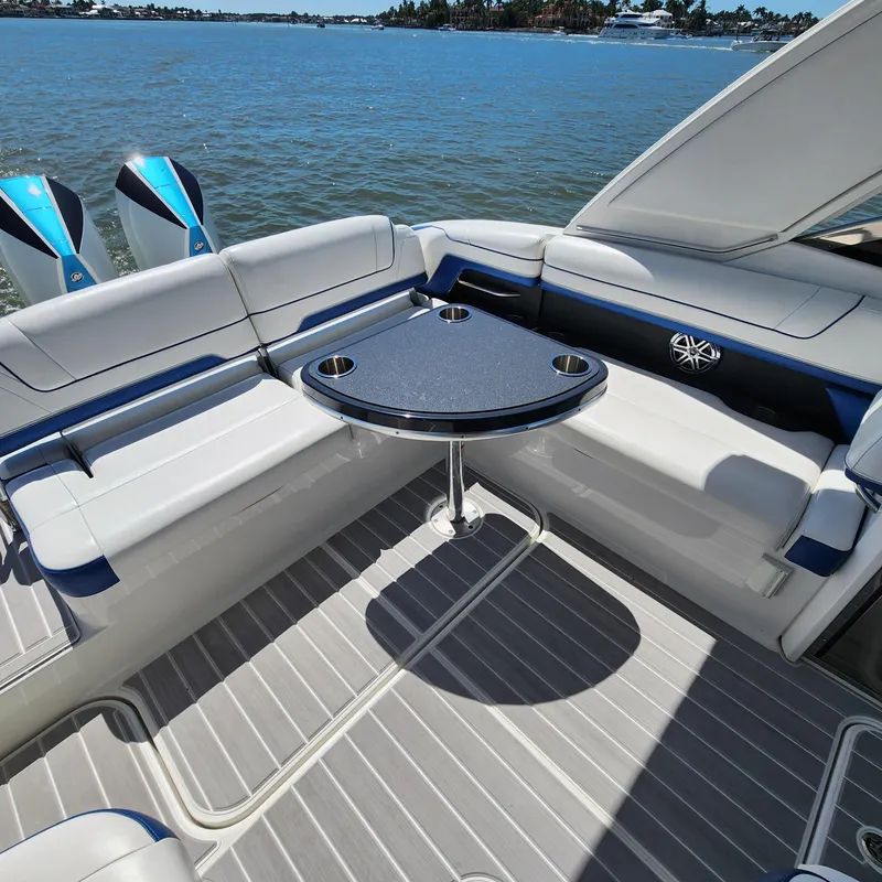 Slide: The Image of 2019 Formula 330 Crossover Bowrider OB interior with seating and table on a sunny day. - 24