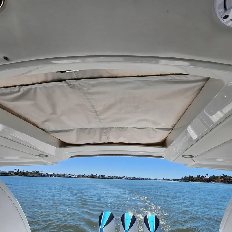 Slide: The Image of 2019 Formula 330 Crossover Bowrider OB cruising on a serene waterway. - 30