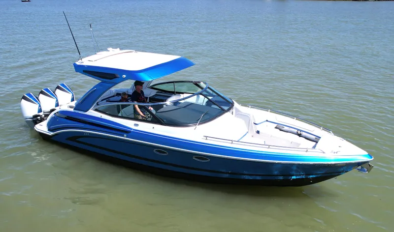 Slide: The Image of 2019 Formula 330 Crossover Bowrider OB on water, featuring sleek blue design and triple outboard engines. - 43