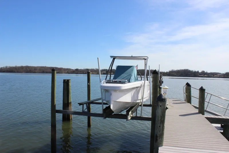 Slide: The Image of 2022 Axopar 22 T Top boat docked on a sunny day by the water. - 6