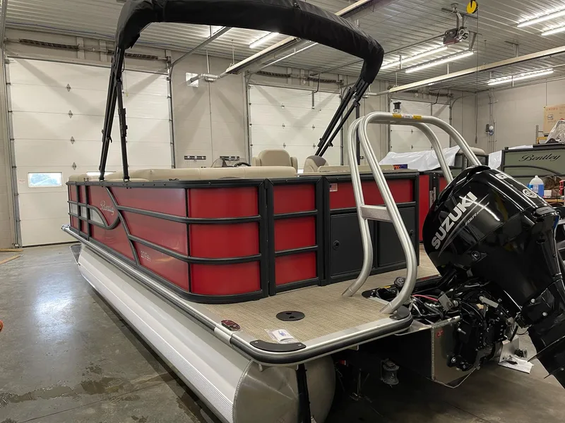 Slide: The Image of 2025 Bentley Pontoons 200 Fish-N-Cruise in a garage, featuring a Suzuki outboard motor. - 5