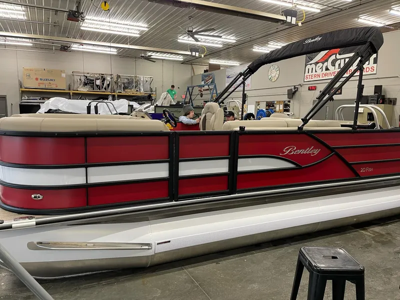 Slide: The Image of 2025 Bentley Pontoons 200 Fish-N-Cruise in a showroom, featuring a sleek red and white design. - 6