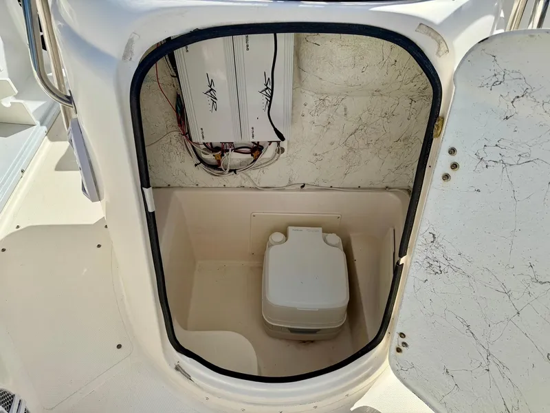 Slide: The Image of 2008 Hurricane FunDeck 211 O/B boat interior with portable toilet and wiring. - 12