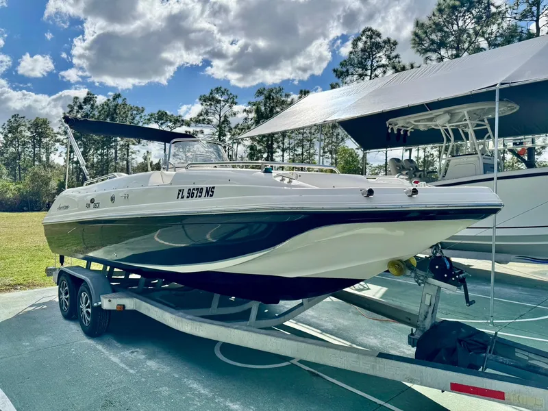 Slide: The Image of 2008 Hurricane FunDeck 211 O/B boat on trailer, parked outdoors under a cloudy sky. - 3