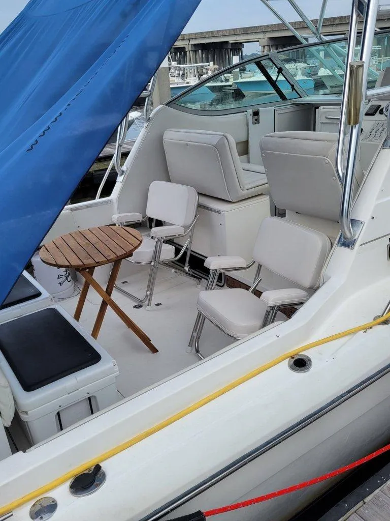 Slide: The Image of 2005 Stamas 290 Express boat interior with seating and table, docked at marina. - 10