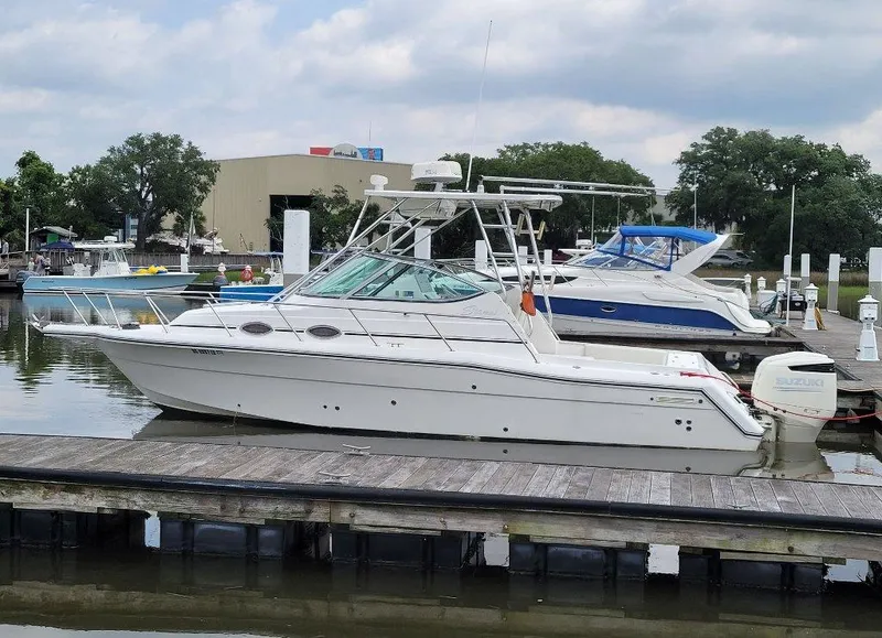 Slide: The Image of 2005 Stamas 290 Express boat docked at a marina under cloudy skies. - 2