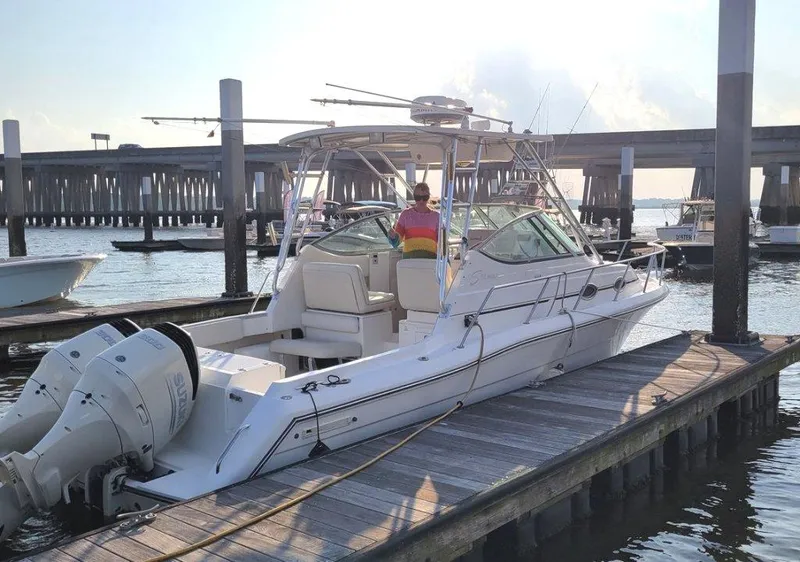 Slide: The Image of 2005 Stamas 290 Express boat docked at marina with bridge in background. - 3