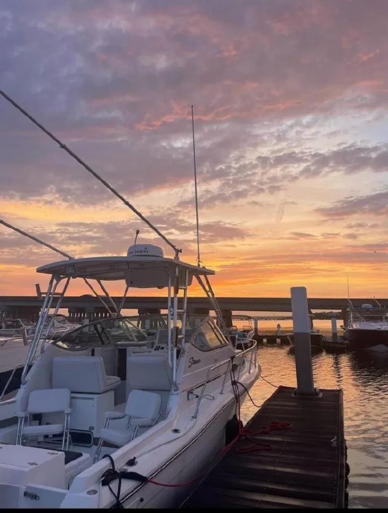 Slide: The Image of 2005 Stamas 290 Express boat docked at sunset with vibrant sky. - 4