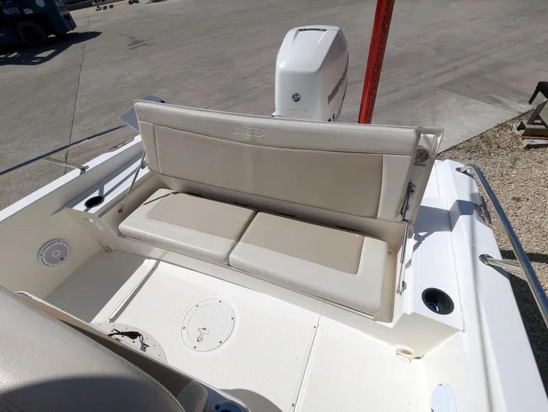 Slide: The Image of 2017 Boston Whaler 240 Dauntless boat with cushioned seating and outboard motor. - 20