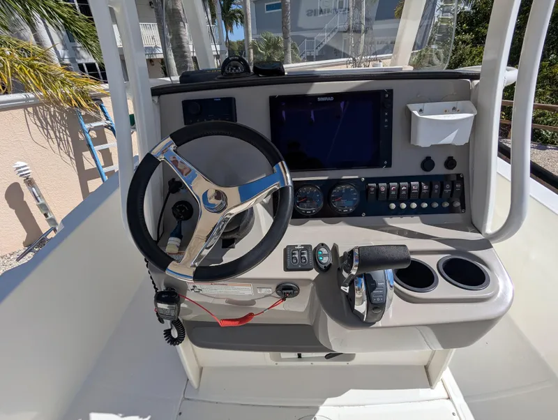 Slide: The Image of 2017 Boston Whaler 240 Dauntless helm with steering wheel, controls, and navigation display. - 5