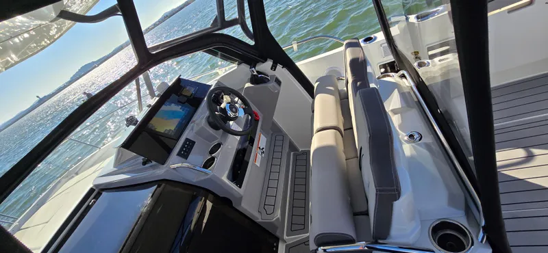Slide: The Image of 2022 Leader 7.5 WA boat interior with modern dashboard and seating on water. - 12