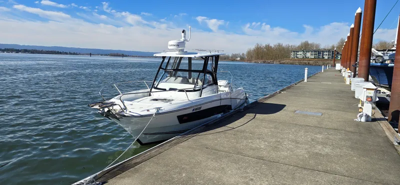 Slide: The Image of 2022 Leader 7.5 wa boat docked at a marina on a sunny day. - 2
