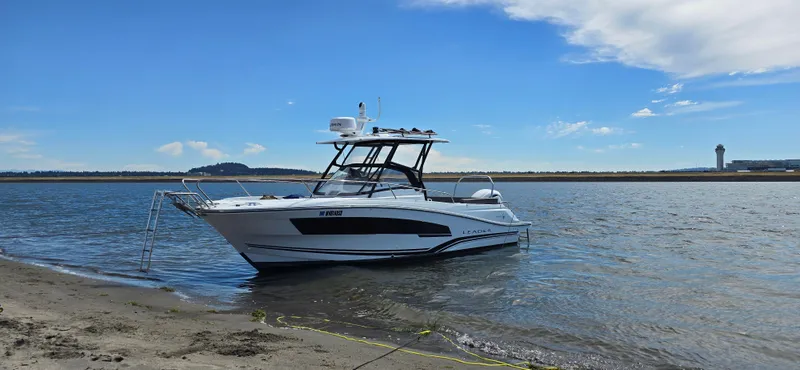 Slide: The Image of 2022 Leader 7.5 WA boat anchored near sandy shore under blue sky. - 6