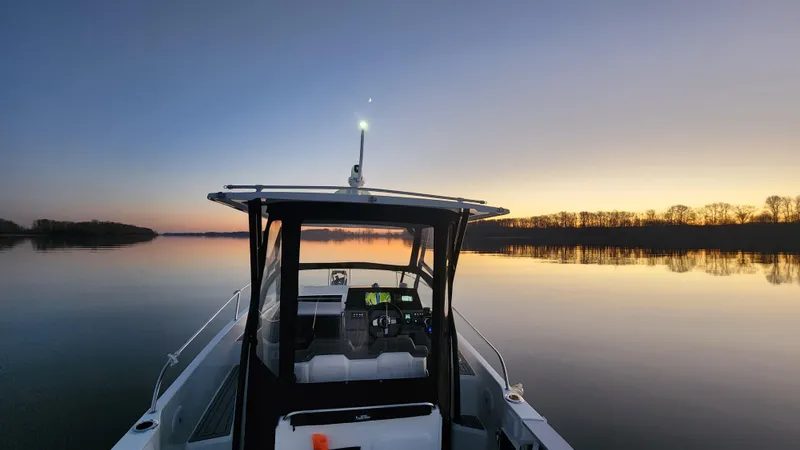 Slide: The Image of Leader 7.5 wa 2022 boat on calm water at sunset. - 7