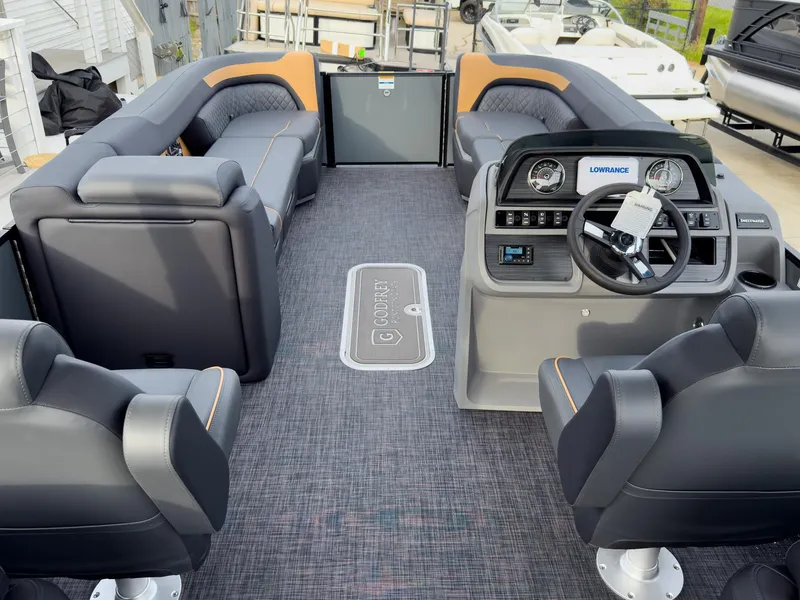 Slide: The Image of 2025 Godfrey Sweetwater 22' Split Bench Tritoon interior with modern seating and steering console. - 13