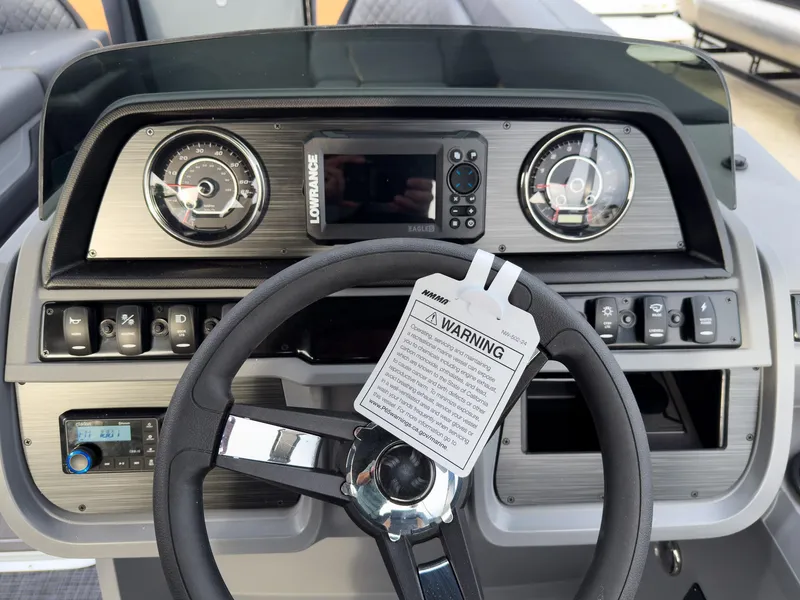Slide: The Image of Steering console of 2025 Godfrey Sweetwater 22' Split Bench Tritoon, featuring gauges and controls. - 14