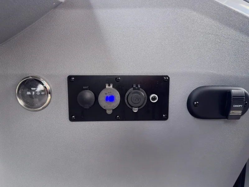 Slide: The Image of Control panel of 2025 Godfrey Sweetwater 22' Split Bench Tritoon, featuring various switches and outlets. - 17