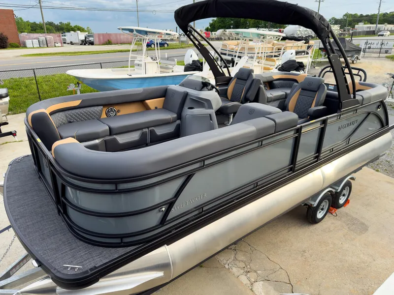 Slide: The Image of 2025 Godfrey Sweetwater 22' Split Bench Tritoon on trailer, featuring sleek design and spacious seating. - 26