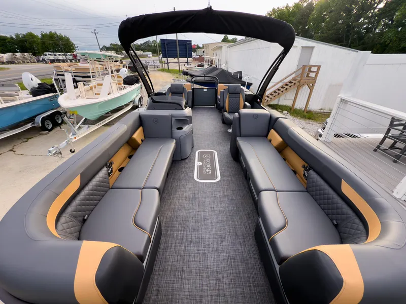 Slide: The Image of 2025 Godfrey Sweetwater 22' Tritoon with spacious seating and modern design, docked outdoors. - 6