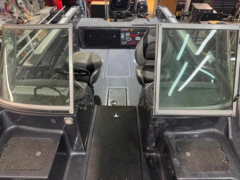 Slide: The Image of Interior of a 2016 Warrior V2121 boat with dual seats and dashboard controls. - 12