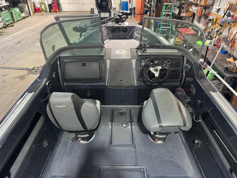 Slide: The Image of 2016 Warrior V2121 boat interior with dual seats and dashboard in a workshop setting. - 13