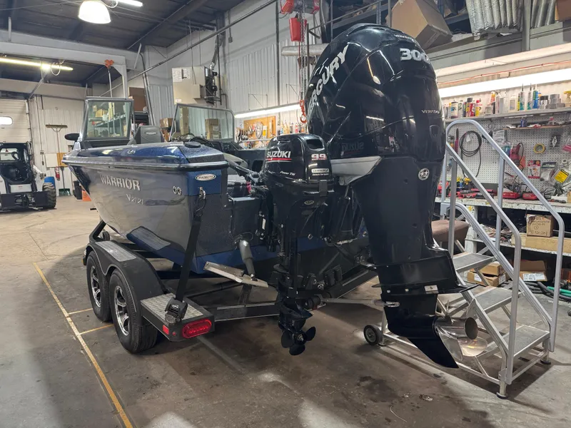 Slide: The Image of 2016 Warrior V2121 boat with Mercury outboard motor in a workshop setting. - 2