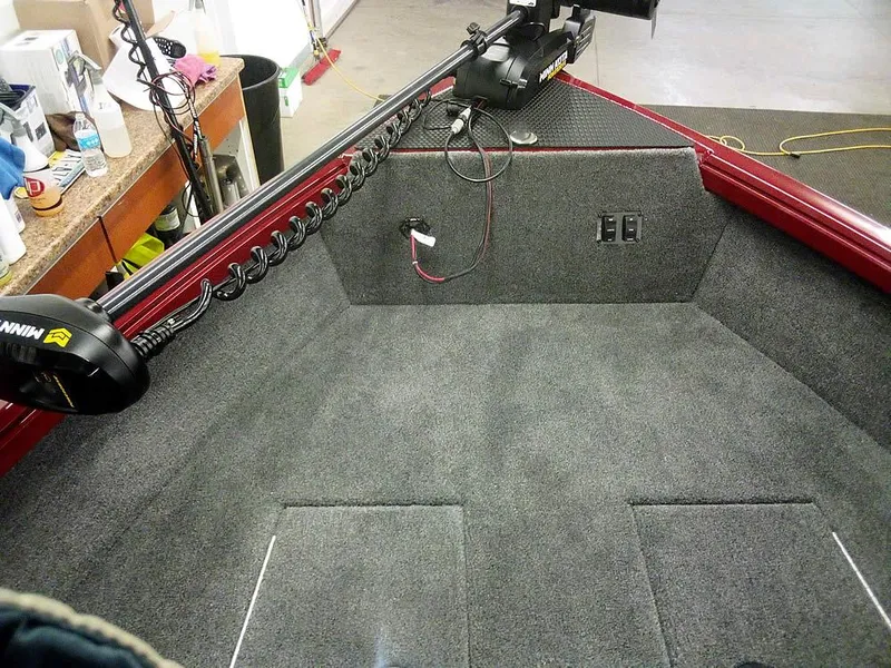 Slide: The Image of 2025 Ranger VS1665 SC boat interior with carpeted deck and mounted trolling motor. - 16