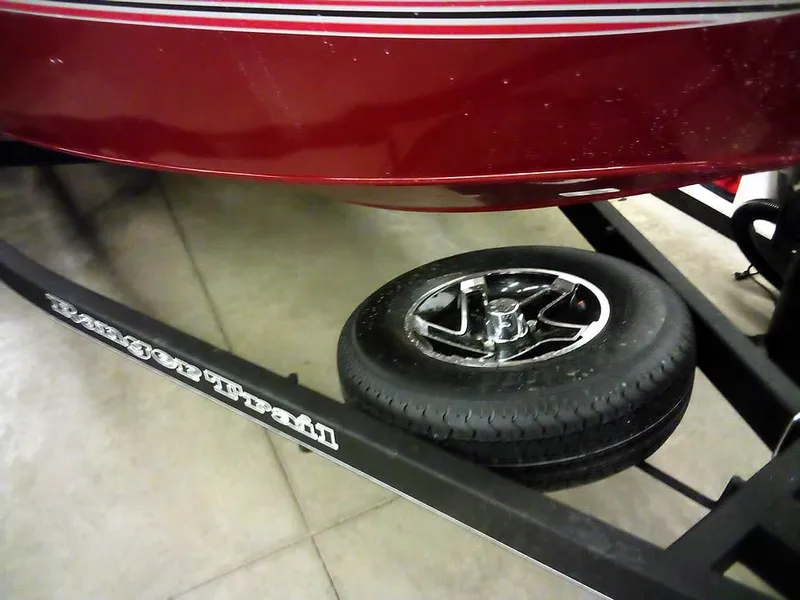 Slide: The Image of 2025 Ranger VS1665 SC boat on trailer with spare tire, red hull, and black frame. - 3