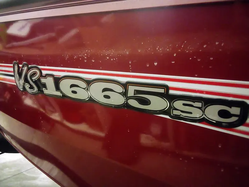 Slide: The Image of 2025 Ranger VS1665 SC boat model emblem on red surface. - 4