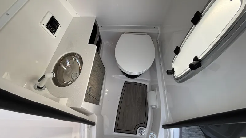 Slide: The Image of Compact bathroom in 2025 Monterey M65 boat with sink, toilet, and window. - 17