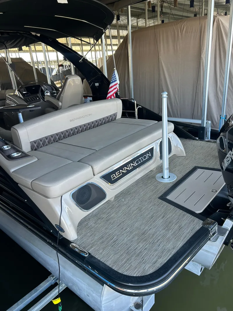 Slide: The Image of 2023 Bennington 25 QSBA pontoon boat with elegant seating and American flag. - 10