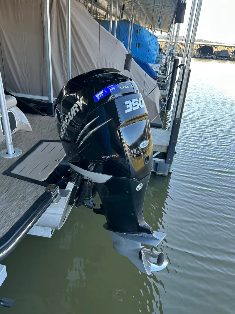 Slide: The Image of 2023 Bennington 25 QSBA with Mercury 350 outboard motor docked on water. - 12