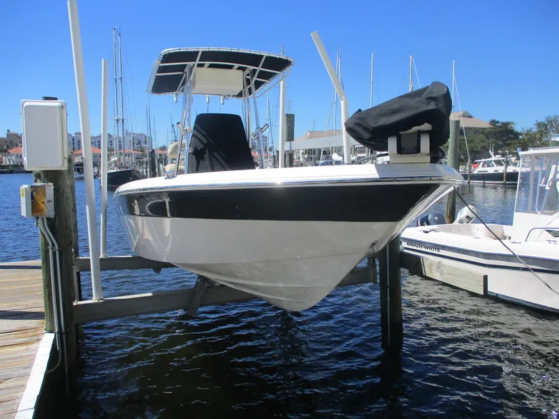 Slide: The Image of 2018 NauticStar 2400 Sport boat docked at marina, clear blue sky. - 1
