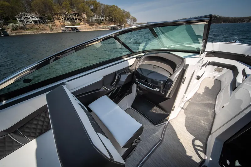 Slide: The Image of 2025 Monterey 275 SS Bowrider interior, featuring sleek seating and modern design on a scenic lake. - 12