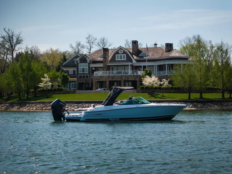 Slide: The Image of 2025 Monterey 275 SS Bowrider on a serene lake near a luxurious waterfront home. - 4