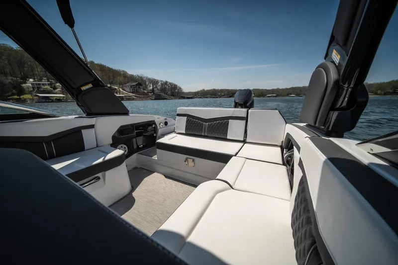 Slide: The Image of 2025 Monterey 275 SS Bowrider interior with luxurious seating on a serene lake. - 13