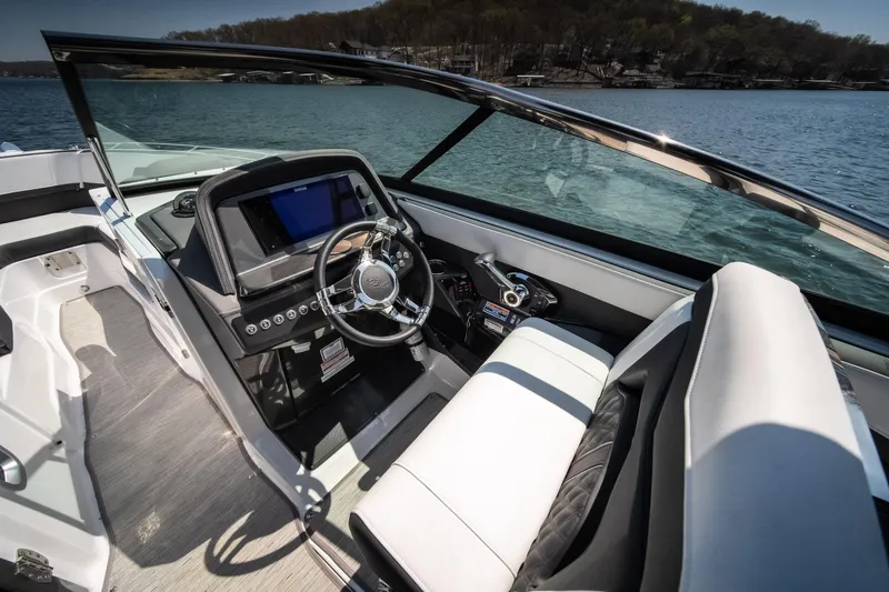 Slide: The Image of 2025 Monterey 275 SS Bowrider interior with sleek dashboard and steering wheel on a sunny lake. - 8