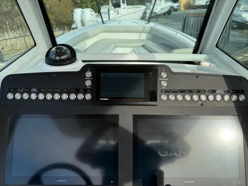 Slide: The Image of 2020 Everglades 273 Center Console boat dashboard with Garmin displays and controls. - 15