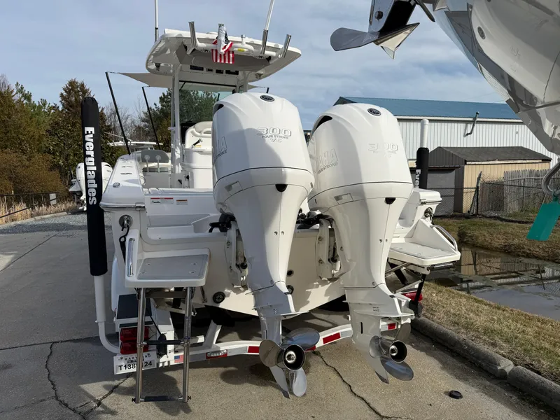 Slide: The Image of 2020 Everglades 273 Center Console boat with twin outboard engines, docked outdoors. - 2