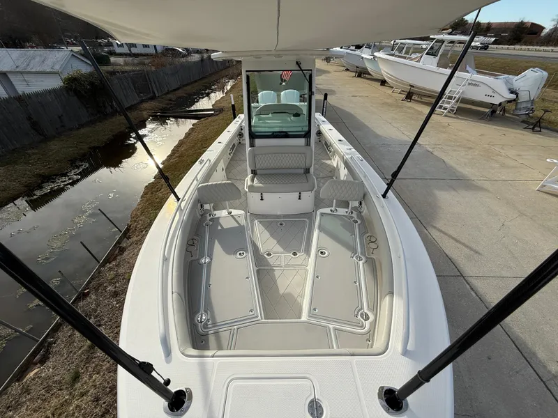 Slide: The Image of 2020 Everglades 273 Center Console boat, spacious deck, sleek design, docked outdoors. - 26