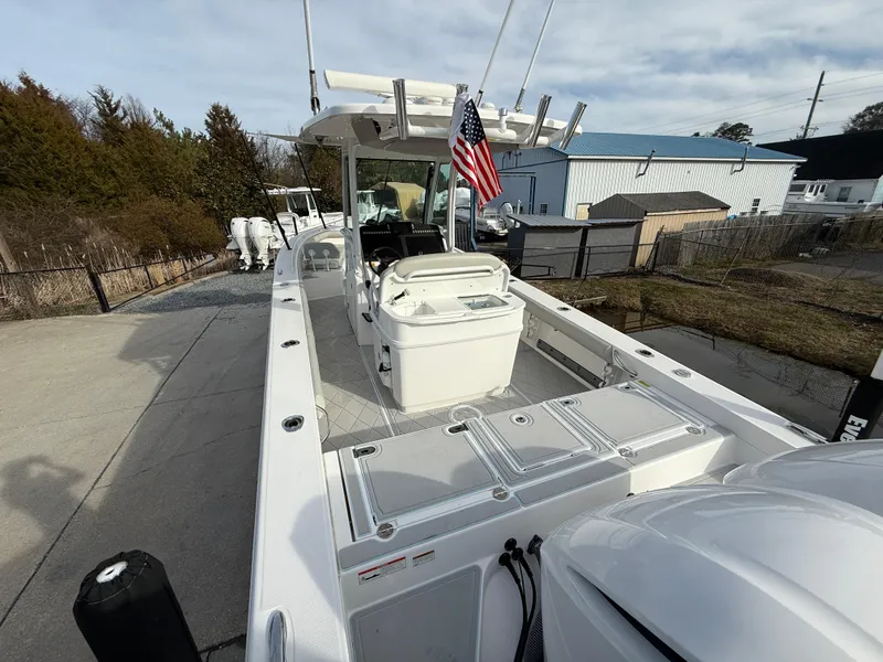 Slide: The Image of 2020 Everglades 273 Center Console boat with American flag, docked outdoors. - 5
